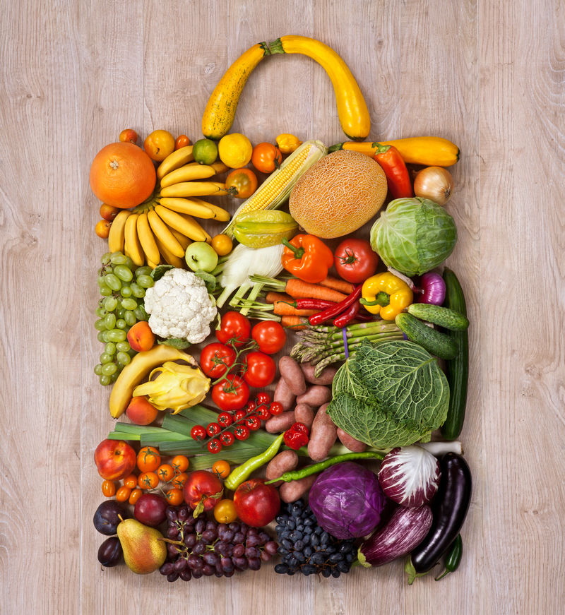 健康食品购物/木桌上不同水果蔬菜制作的名牌手袋食品摄影
