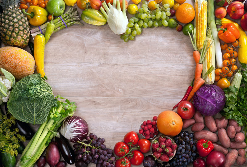 心形食物/食物用木桌上不同水果和蔬菜制成的心脏摄影