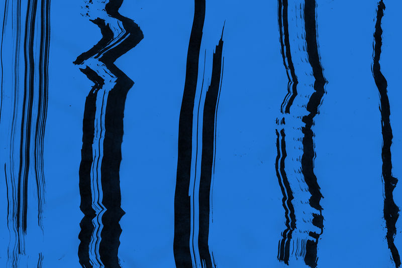 黑色纸张背景上的蓝色墨水和水彩纹理-干刷笔划效果