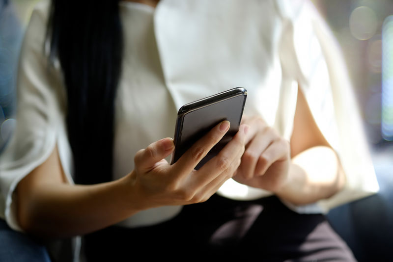 一个不可辨认的女商人在办公室使用手机的短镜头。