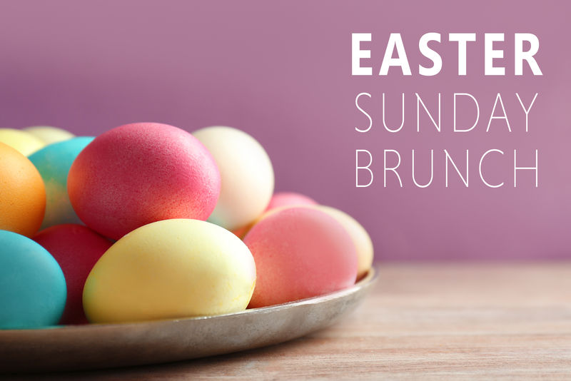 木桌上有彩色复活节彩蛋的金属盘，特写