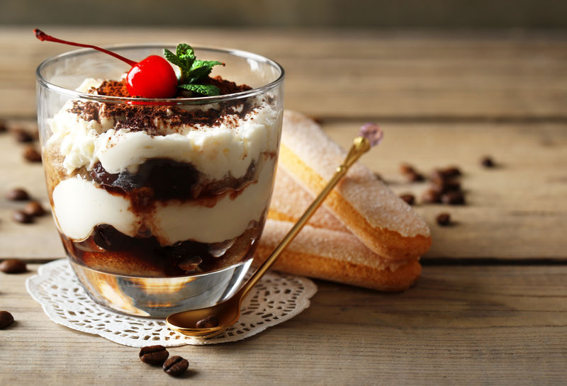 美味的提拉米苏酒杯，木制背景