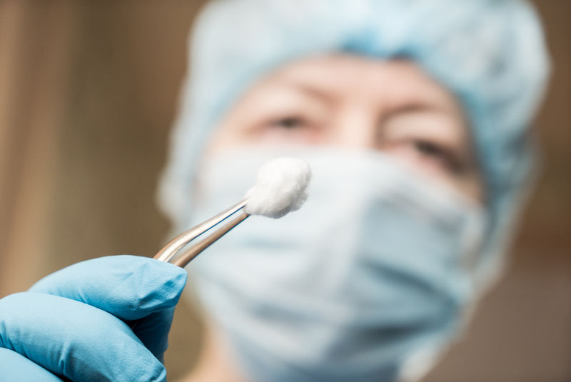 女牙医拿着工具盯着病人看