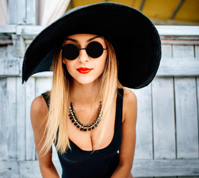 年轻漂亮性感女孩穿着黑色泳衣放松户外