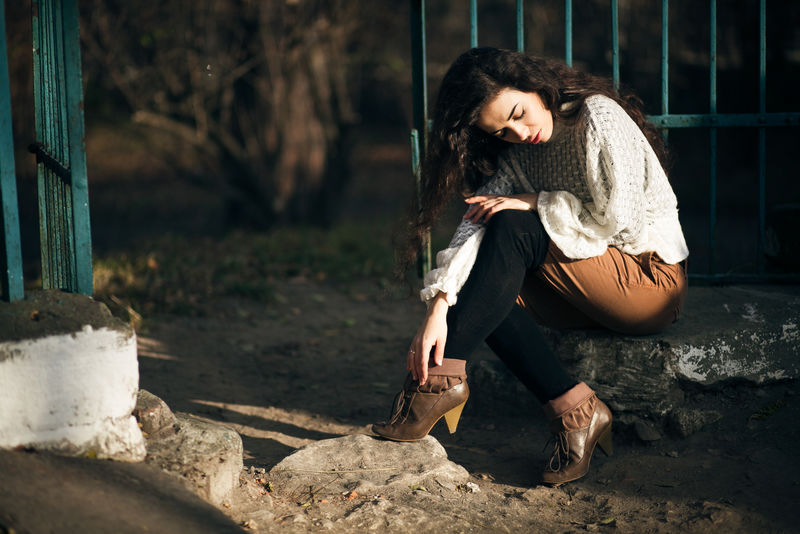 晨曦照耀着坐在石头上的黑发女子