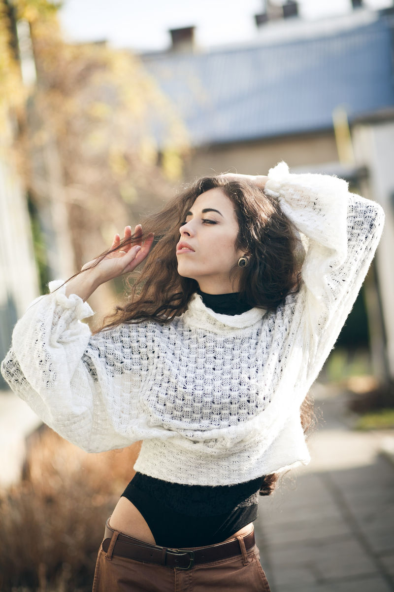 多梦的卷发女士享受秋日的阳光