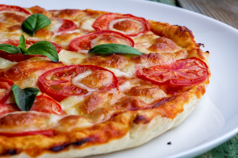 白盘子里有奶酪的披萨。特写镜头