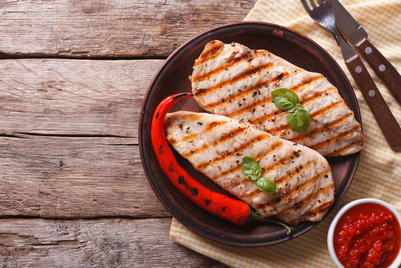 鸡肉胸肉配番茄和胡椒在烤盘上特写-水平视图