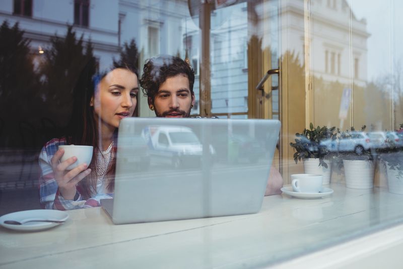 夫妻俩在咖啡厅用笔记本电脑