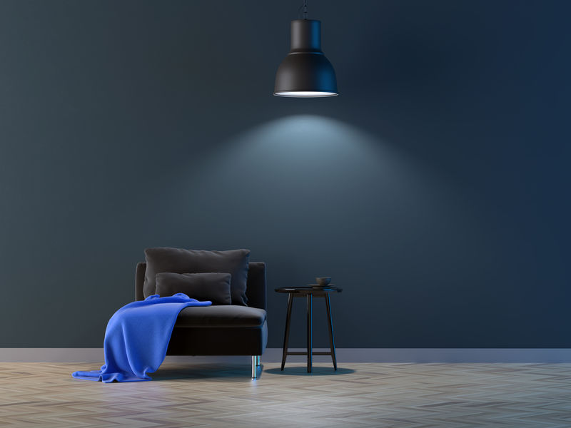 扶手椅上方挂着一盏灯-背景是一堵空墙