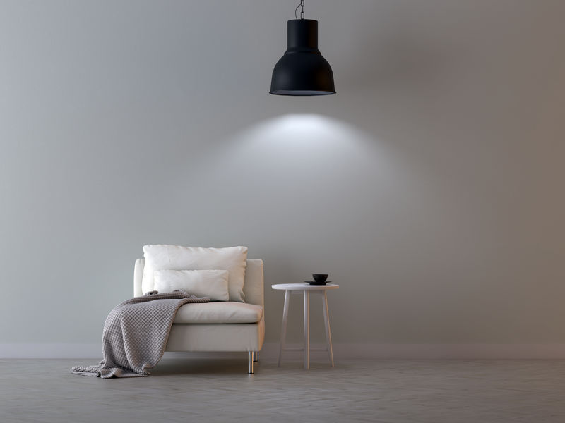 扶手椅上方挂着一盏灯-背景是一堵空墙