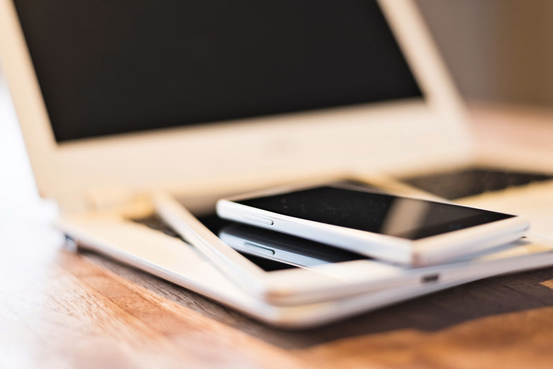 笔记本电脑上的手机和平板电脑-特写图片