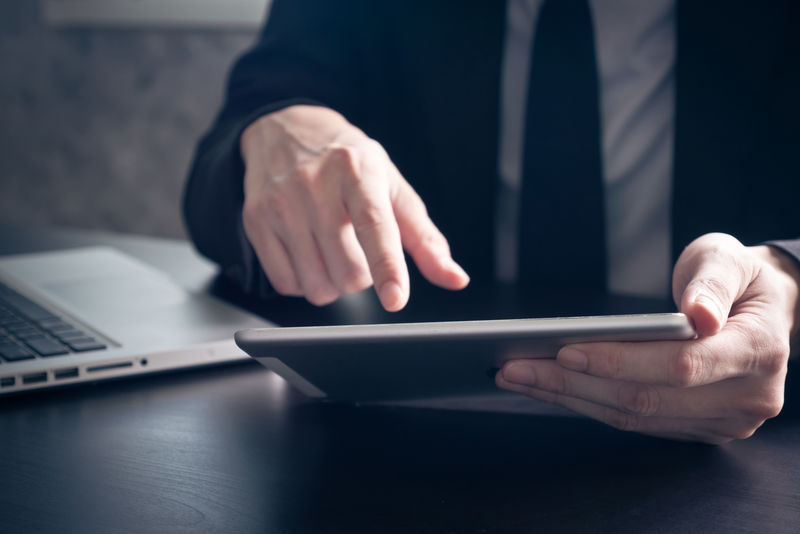商务人士在办公桌上使用平板电脑的特写镜头