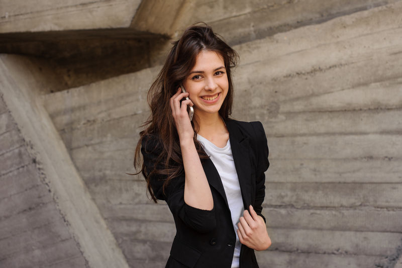 年轻快乐的女孩在打电话，看着镜头