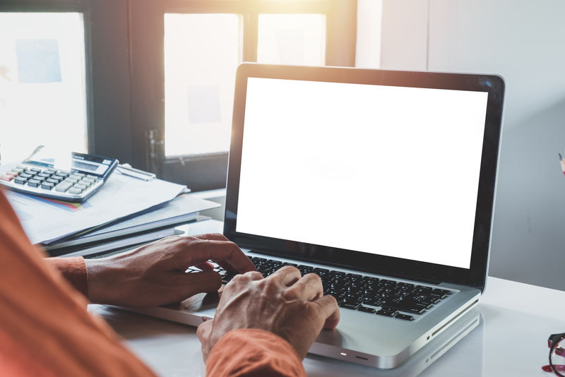 办公桌模型的概念-模型的现代台式机与商务人员使用的空白屏幕笔记本电脑和办公桌上的许多东西的手