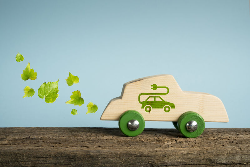 生态汽车的概念-木制玩具车-侧面印有树叶和电气插头符号