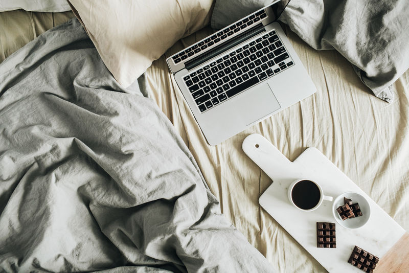 笔记本粉彩亚麻早餐大理石切割板上有咖啡和巧克力平铺