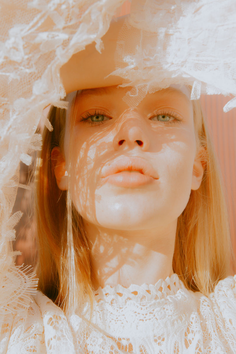 女人用胳膊遮住前额向下看