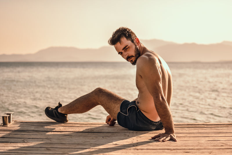 坐在沙地前的棕色木桌上的男人