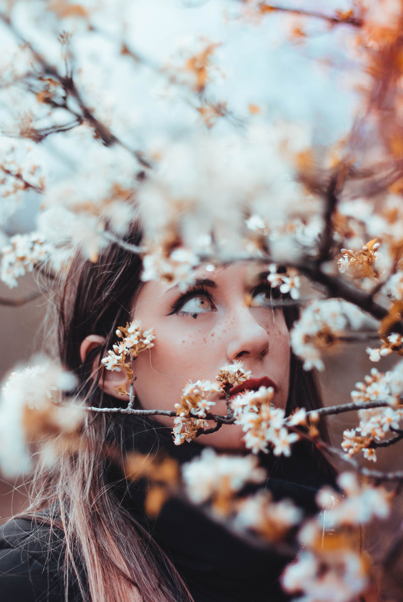 站在白树前选择性聚焦拍照的女人