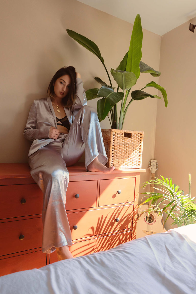 坐在盆栽旁餐具柜上的女人