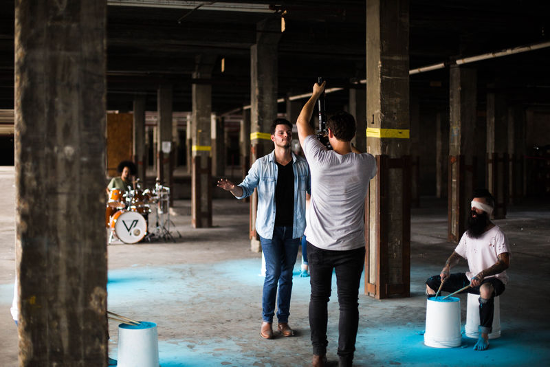 两个男人站在坐在椅子上的男人前面