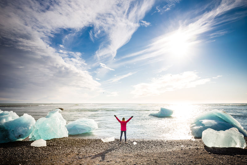 站在水边举起手的女人