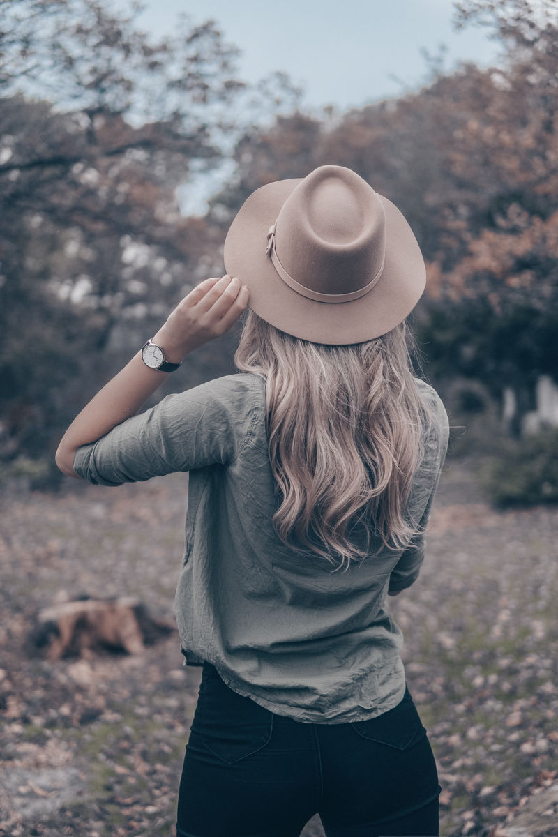 戴着棕色帽子的女人在树旁