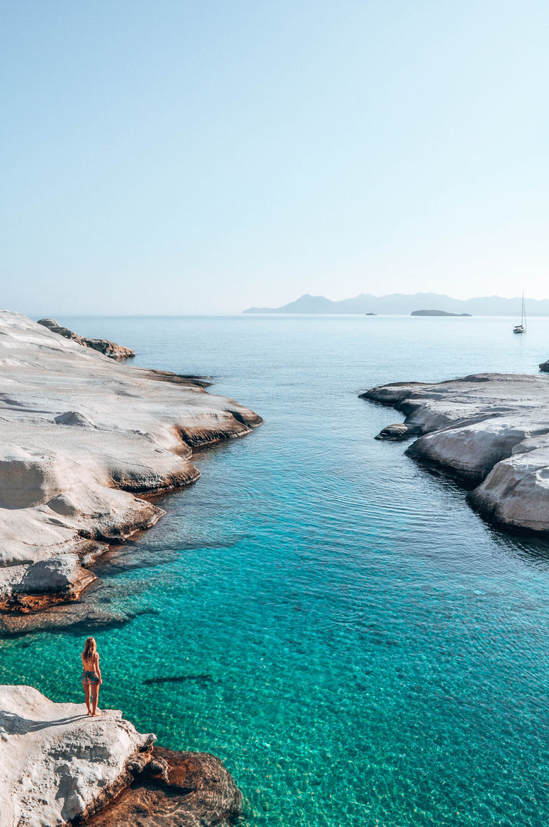 白天站在靠近水体的岩石上的女人