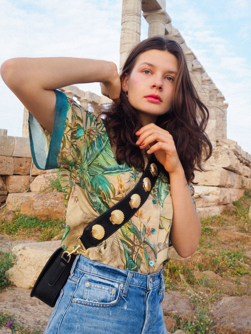 站在废墟旁穿着绿色和棕色T恤的女人