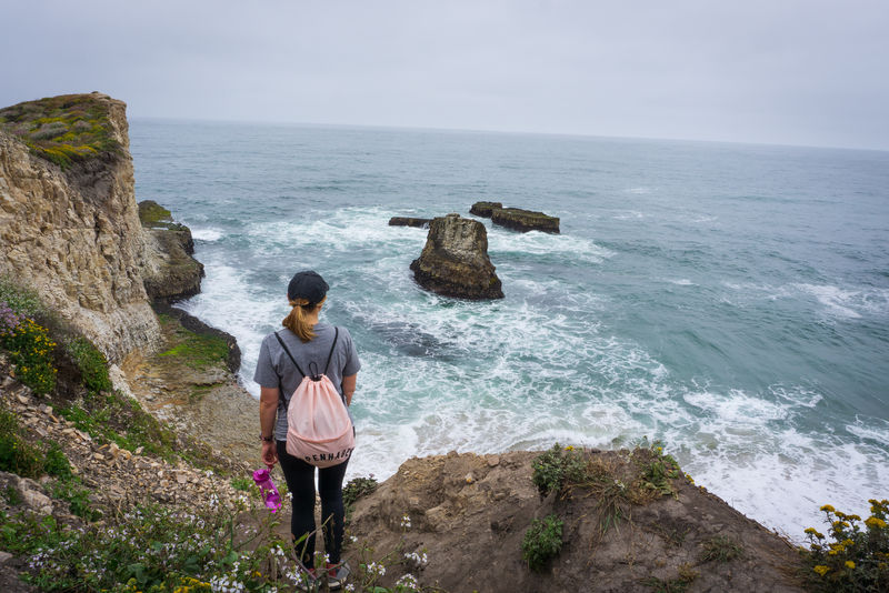 站在悬崖上靠近水面的女人
