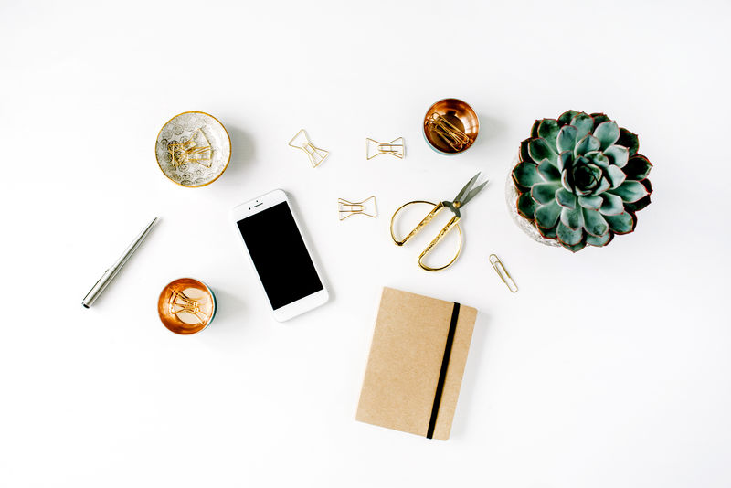 女性书桌工作区-白色背景-有多汁的、电话、剪刀、日记和金夹子-平放俯视图