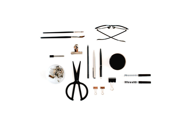 带用品的白色办公桌-咖啡、剪刀、钢笔、夹子、眼镜和白色背景的办公用品-平躺-顶视图办公桌