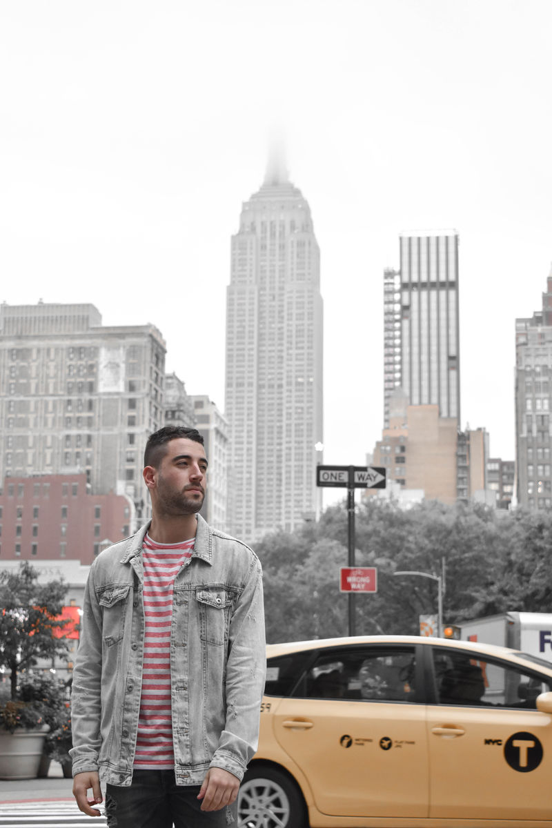 白天穿灰色牛仔纽扣夹克的男子站在黄色轿车附近