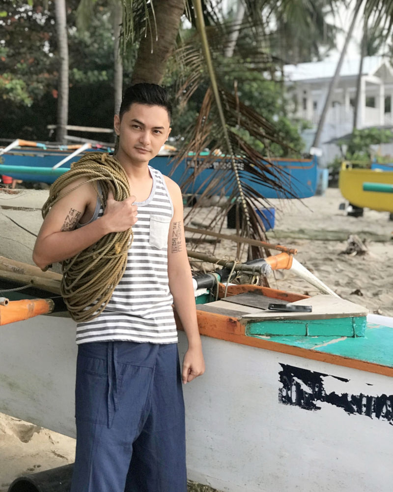 在DA期间在岸上的船旁边肩上扛着绳子的人