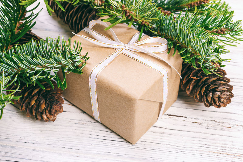 圣诞作文背景。木质背景上有松果和冷杉枝的圣诞礼物。平面布局，俯视图，复制空间。柔和的