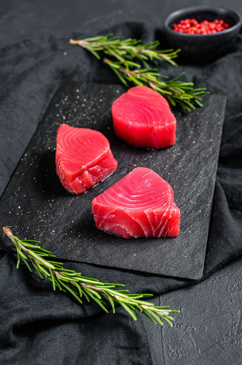 生的红吞拿鱼排。黑色背景。俯视图