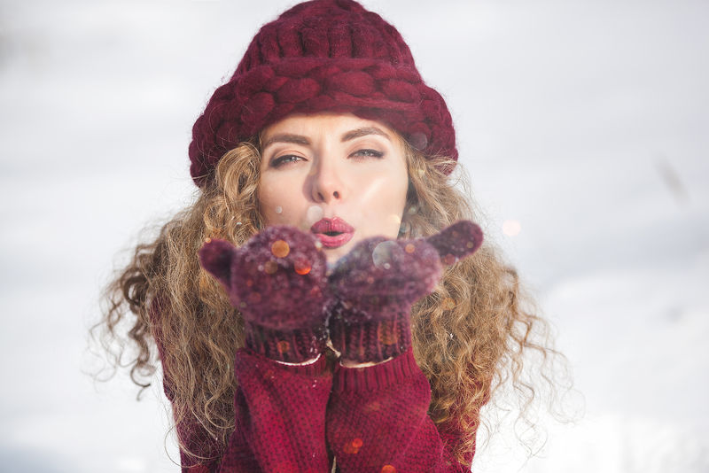 年轻开朗的女子对着镜头吹雪的画像