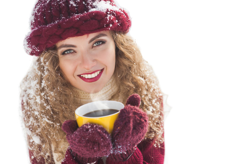 拿着一杯热咖啡的年轻美女特写照片
