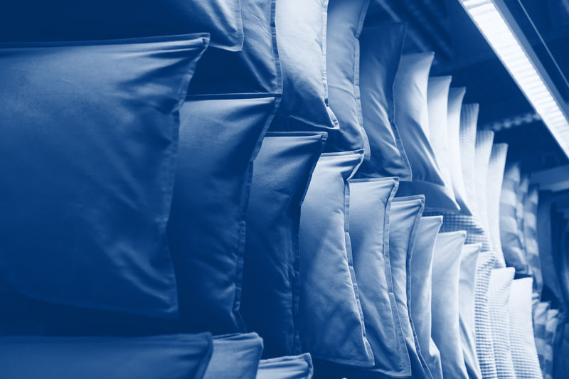 货架陈列柜上的经典蓝色调枕头。2020年流行颜色的靠垫