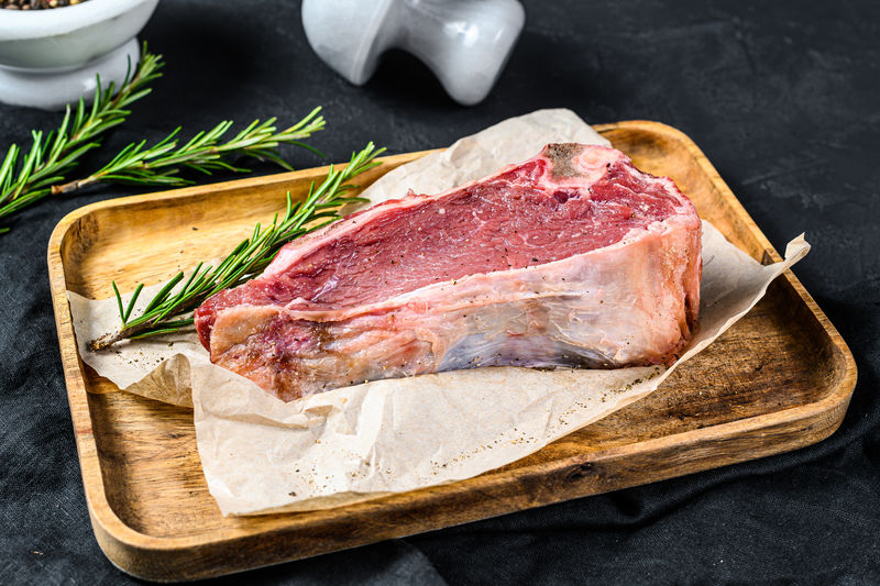 带骨的生牛肉。黑色背景。俯视图