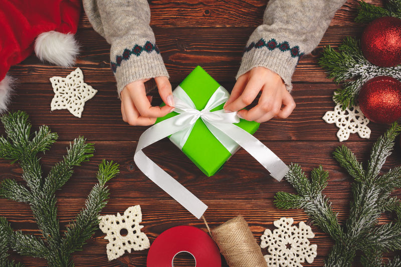 圣诞准备概念。女人近距离包装礼物