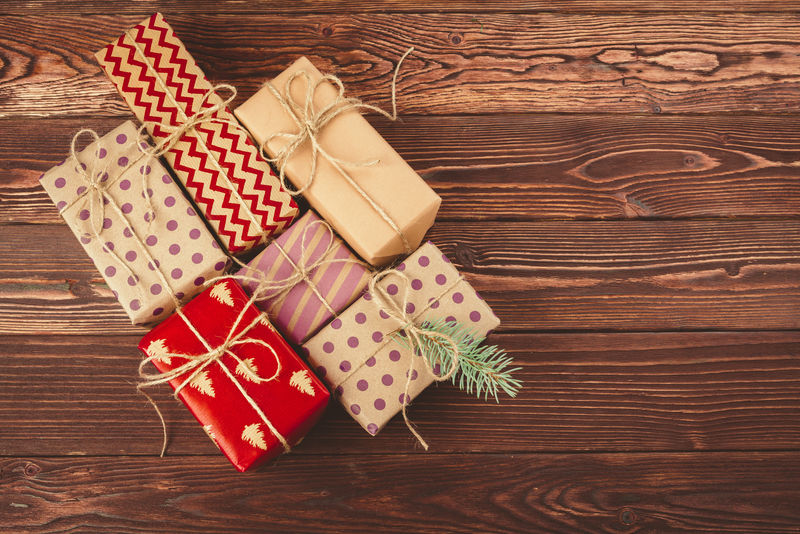 棕色木质背景上装饰时尚的圣诞礼物