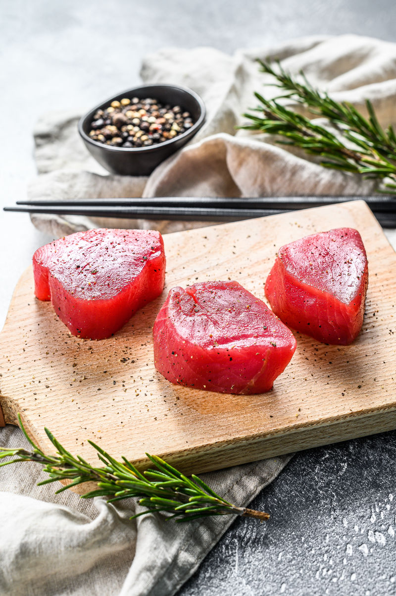 生的红吞拿鱼排。灰色背景。俯视图