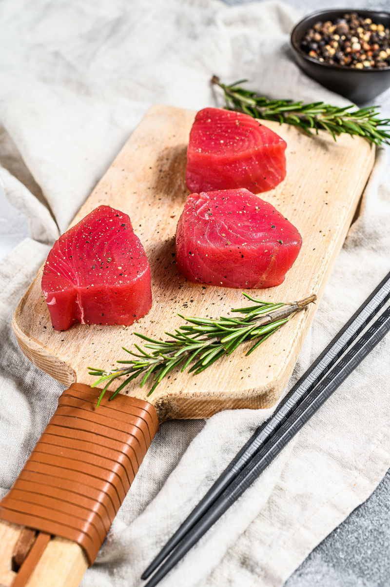 生的红吞拿鱼排。灰色背景。俯视图