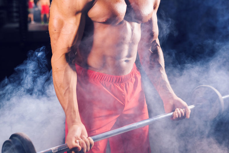 健美男在健身房举重的特写镜头