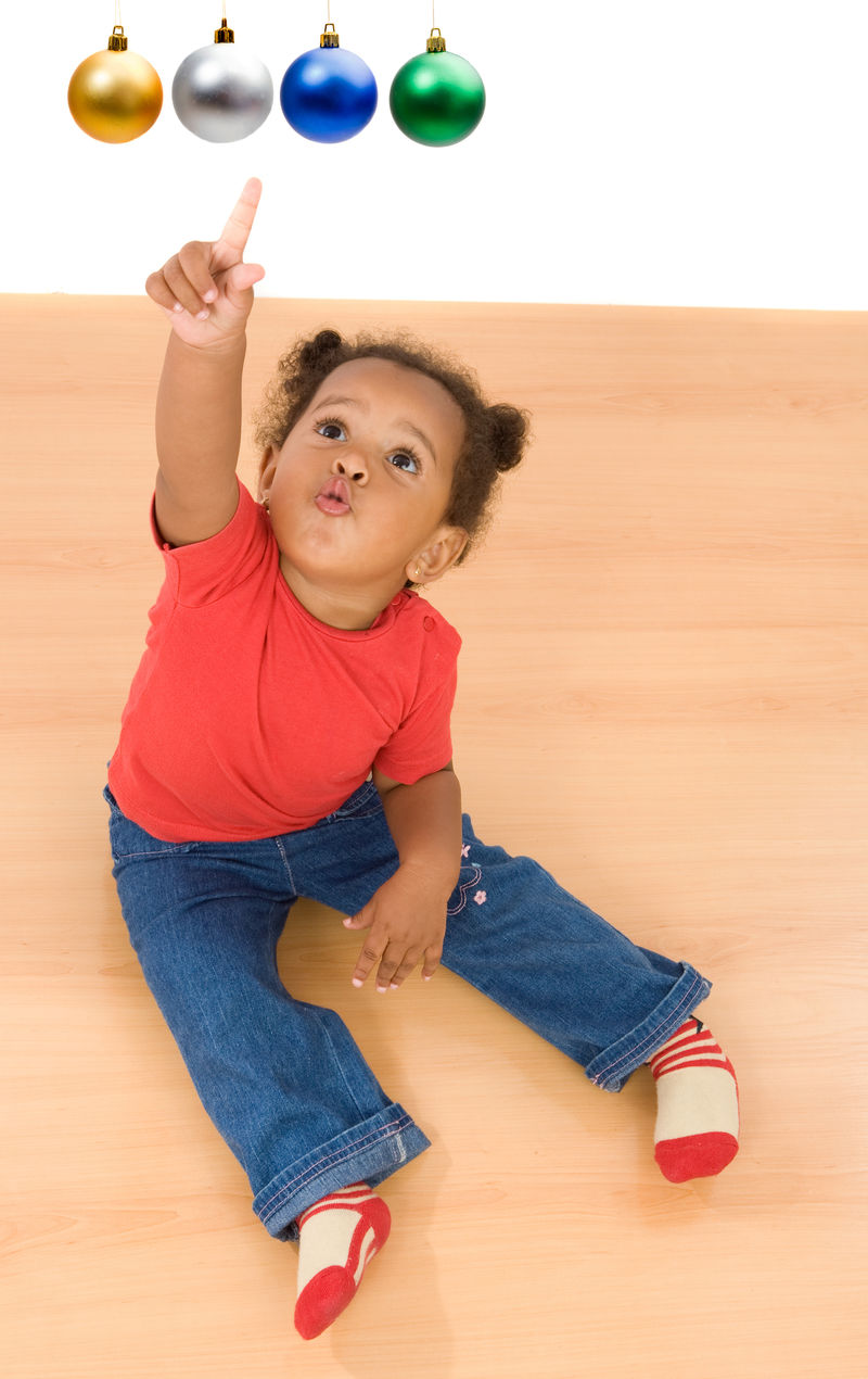 小女孩指着四个圣诞坐球