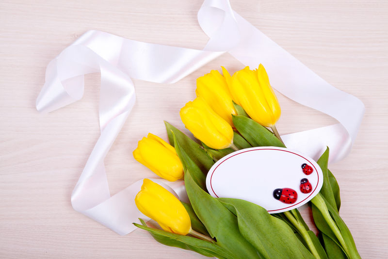 木质背景上的一束鲜黄色郁金香