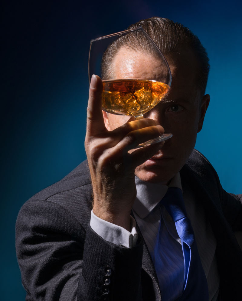 一个男人透过一杯白兰地