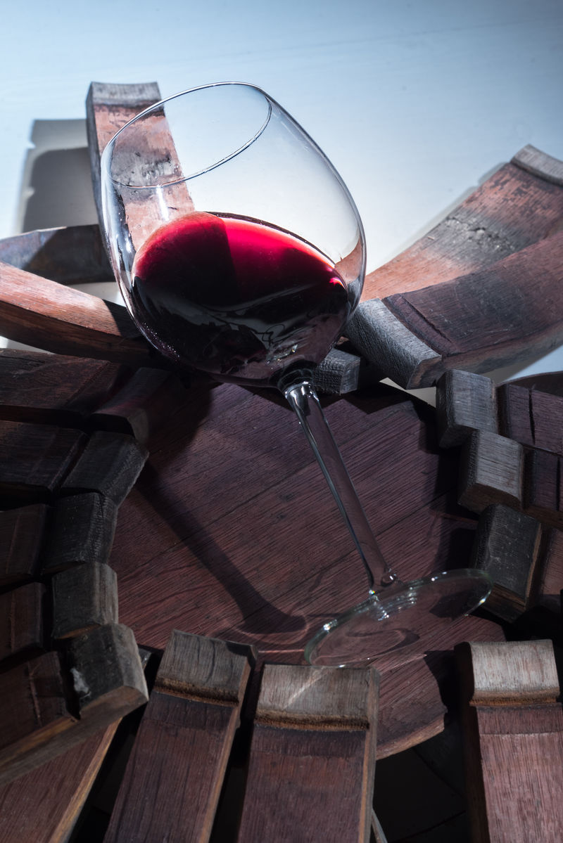 橡木桶废墟上的一杯红酒